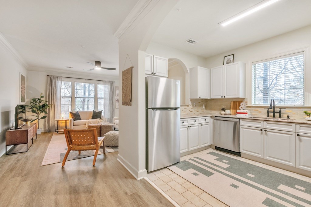 a kitchen with white cabinets and a stainless steel refrigerator