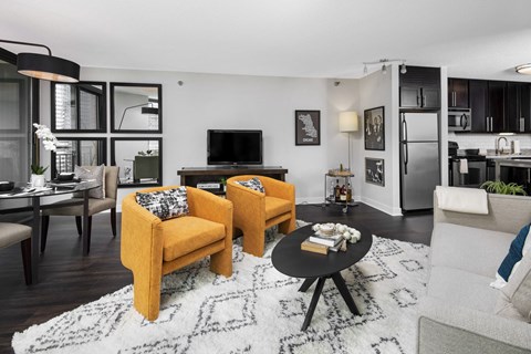 A living room with a yellow chair and a black coffee table.