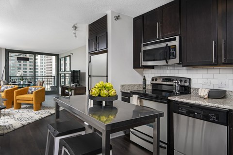 A modern kitchen with dark wood cabinets and stainless steel appliances.