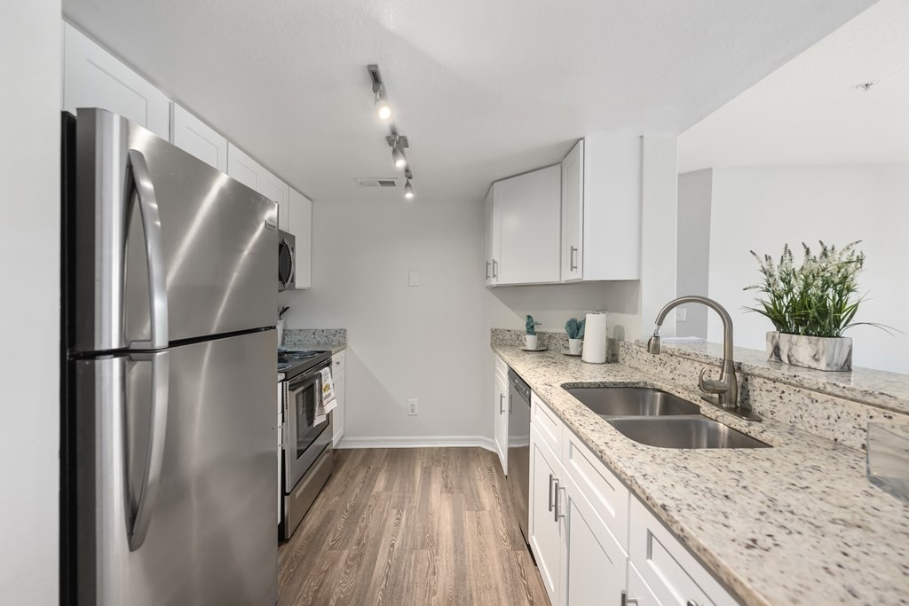 a kitchen with granite counter tops and stainless steel appliances