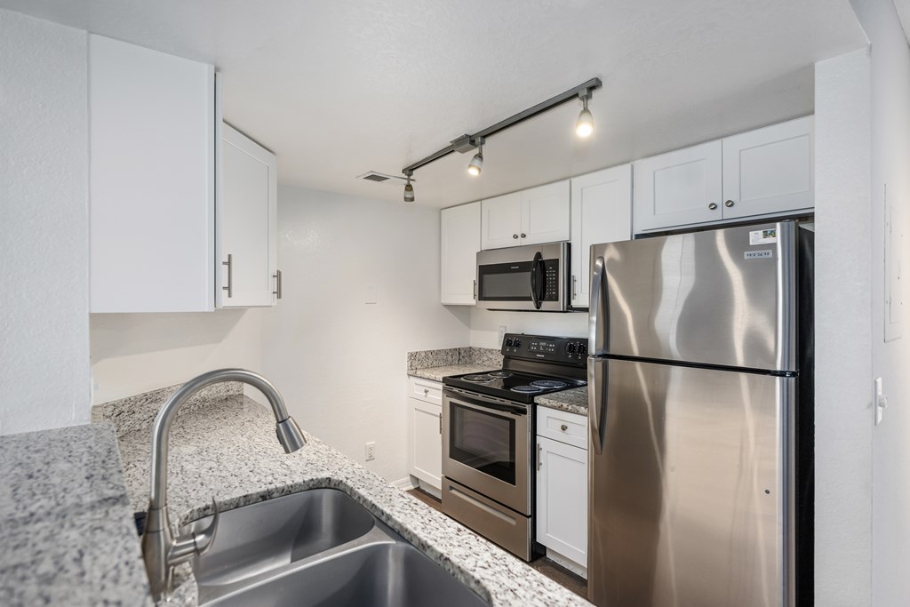 a kitchen with stainless steel appliances and granite counter tops