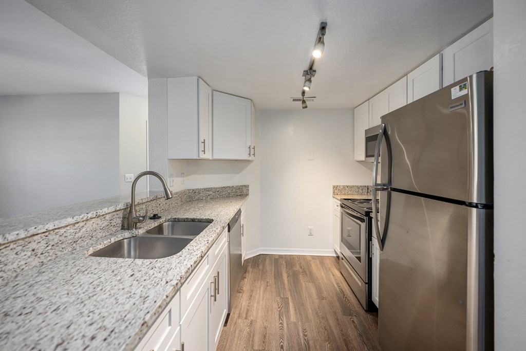 an empty kitchen with granite counter tops and stainless steel appliances