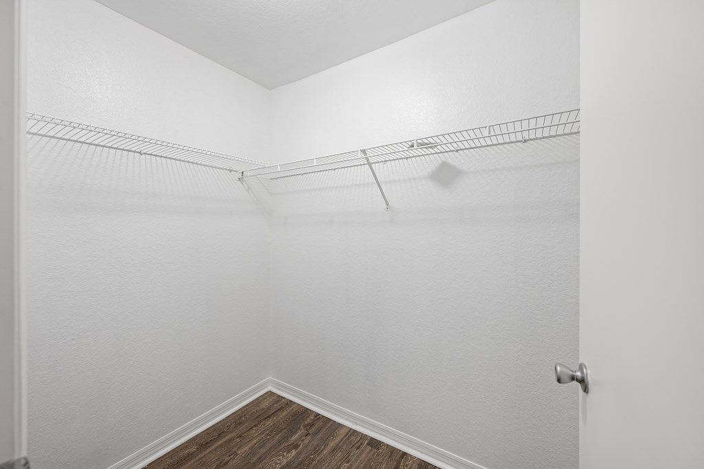 room with white walls and wood flooring and a mirrored closet