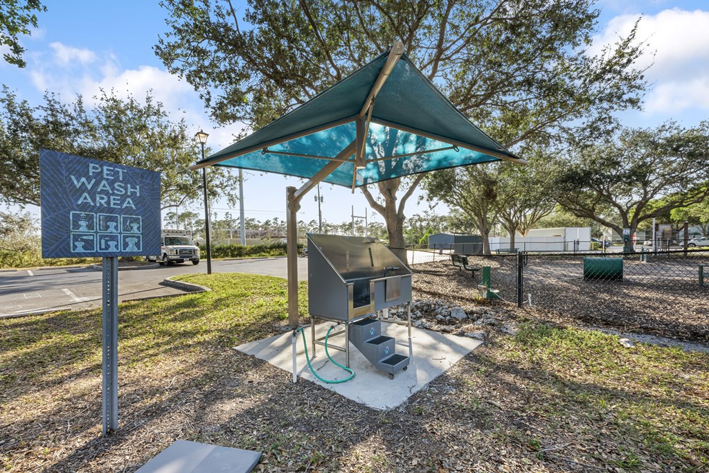 a picnic area with a grill and a sign that reads pet wash area for grill
