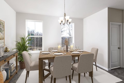 A dining room with a table set for two and a chandelier hanging from the ceiling.