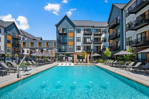 a swimming pool with an apartment building in the background
