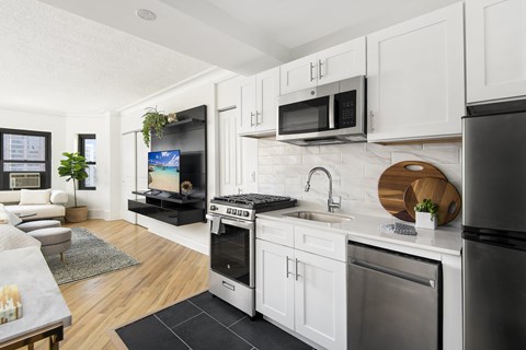 A modern kitchen with white cabinets and stainless steel appliances.
