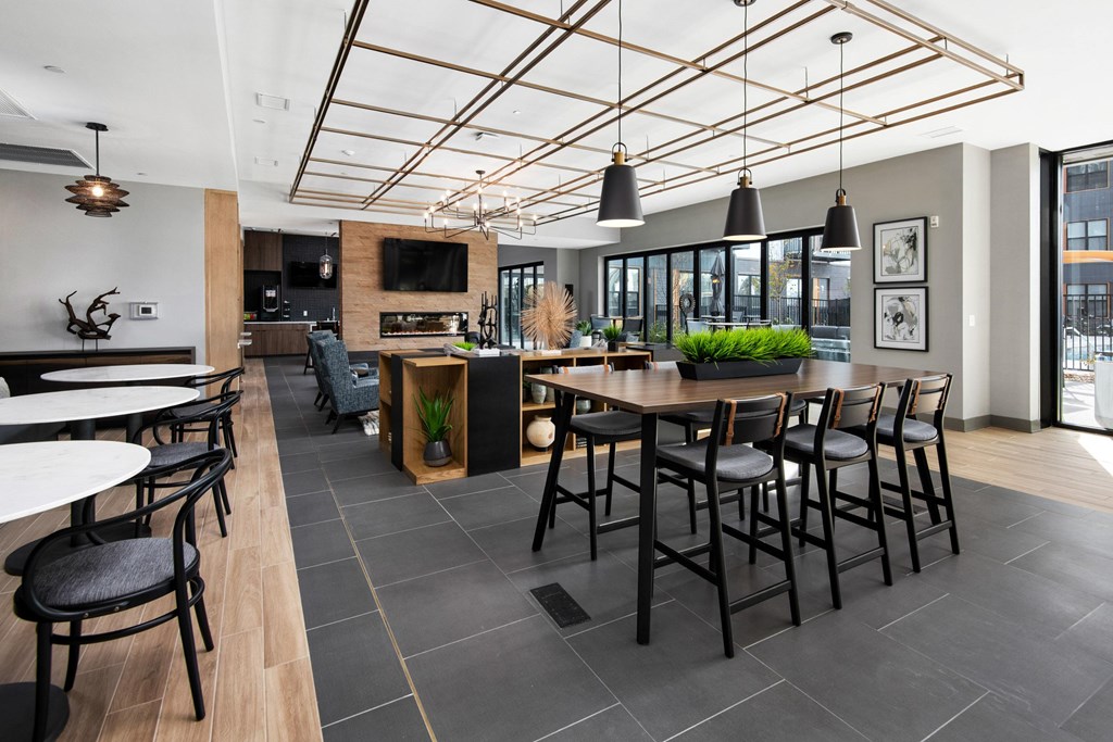 the lobby of a restaurant with tables and chairs and a bar and a kitchen