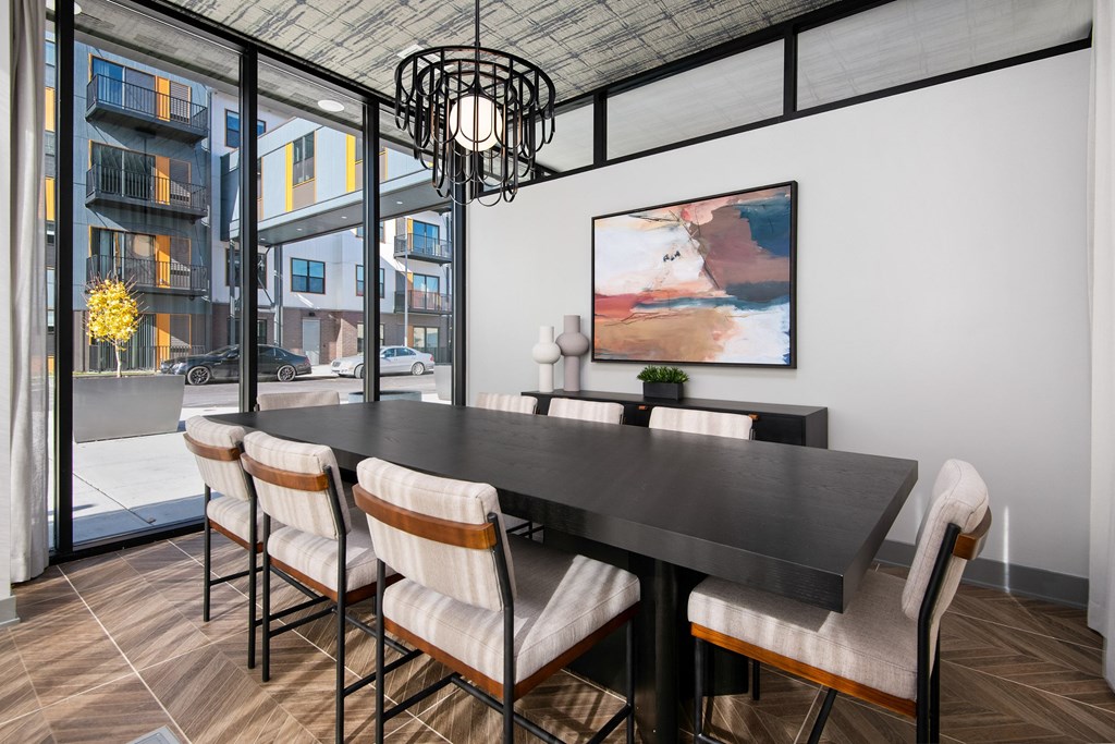 a dining room with a table and chairs and a large window