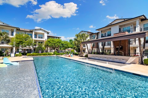 A swimming pool in front of a row of houses.