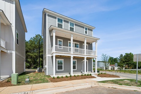 A two-story house with a balcony on the second floor.