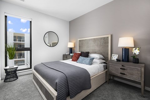 a bedroom with a bed and a large window