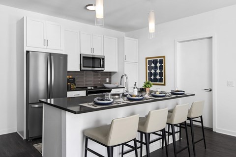 a kitchen with a counter top and a stainless steel refrigerator