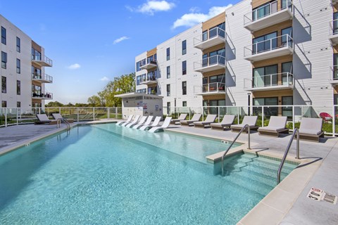 A swimming pool in front of apartment buildings.