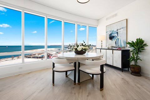 a dining room with a table and chairs and a view of the ocean