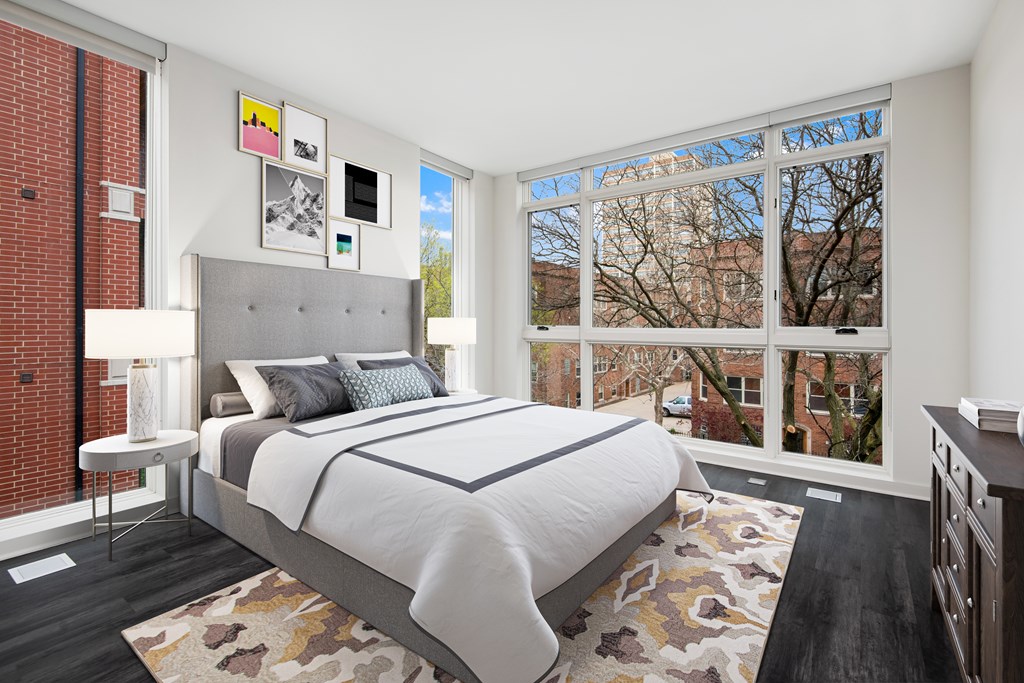 a bedroom with a bed and two windows