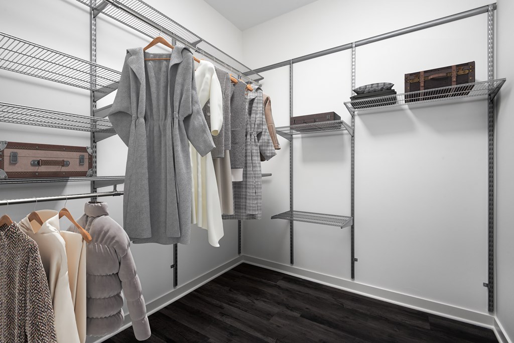 a walk in closet with a variety of clothes hanging on metal racks
