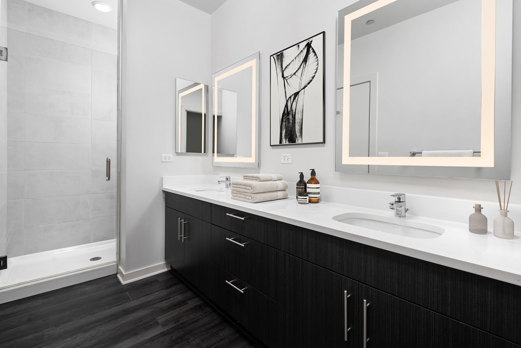 a bathroom with two sinks and mirrors and a shower