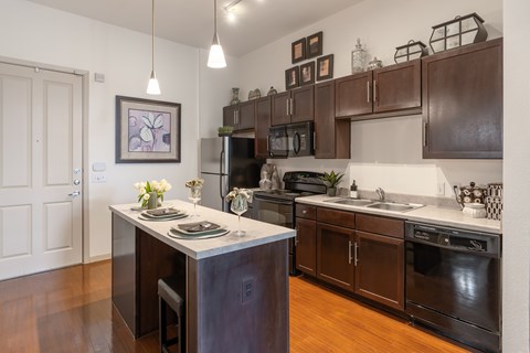 A kitchen with dark brown cabinets and a white island.