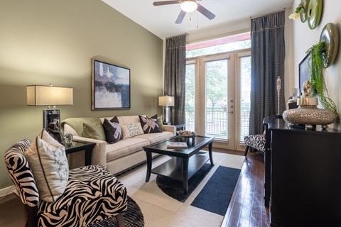 A living room with a zebra print chair and a painting on the wall.