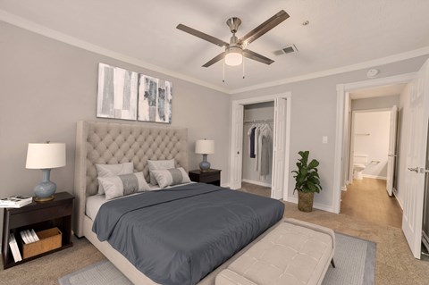 A bedroom with a large bed and a ceiling fan.