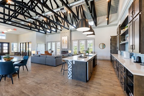 A modern kitchen with a large island and a dining table with chairs.