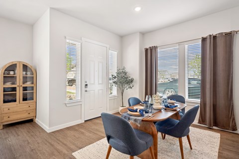 A dining room with a table set for four.