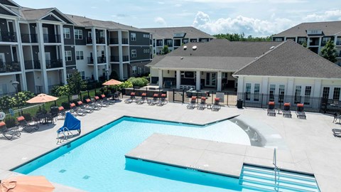 A large swimming pool in front of apartment buildings.