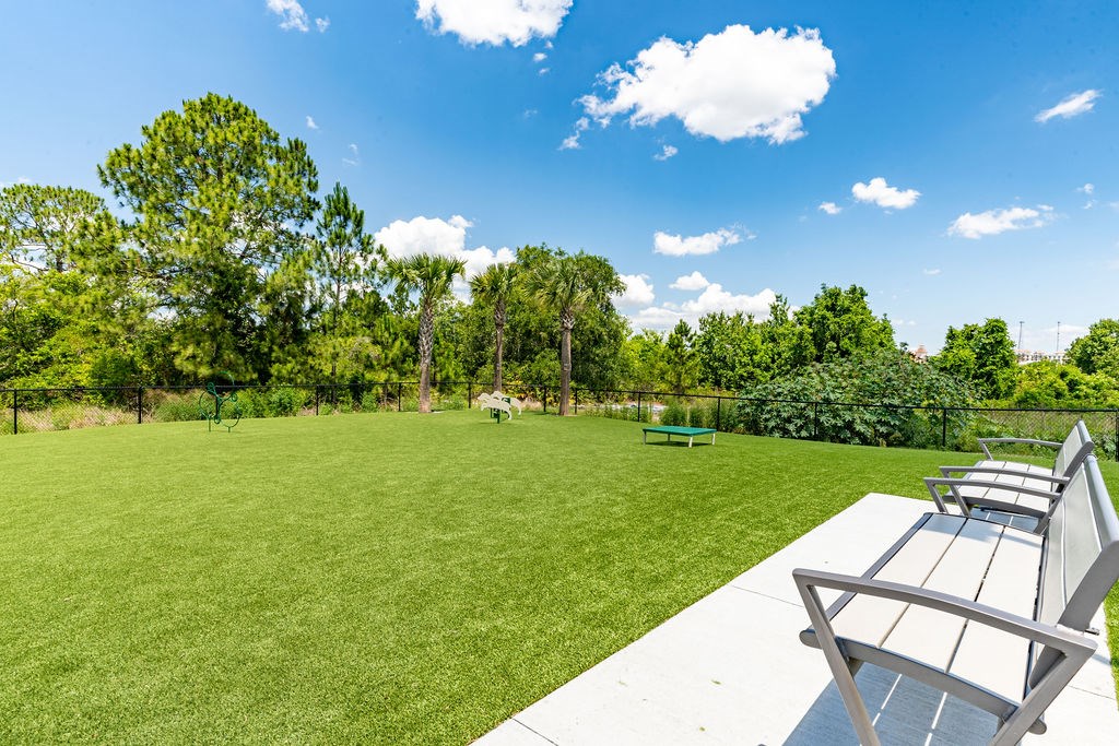 Dog park at westerly apartments with trees, grass, and agility equipment