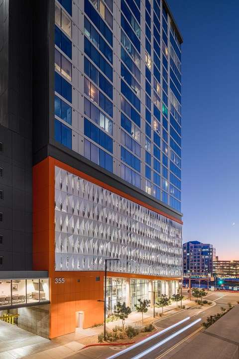 A modern building with a glass facade and a unique orange and white exterior.