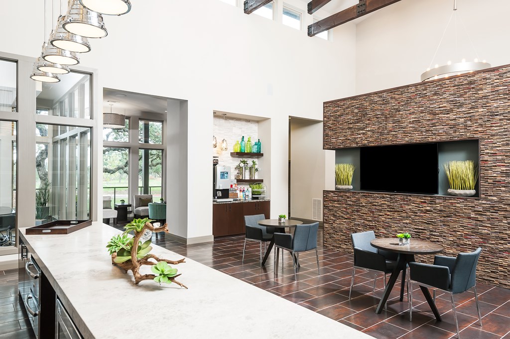 a lobby with a kitchen and a table with chairs
