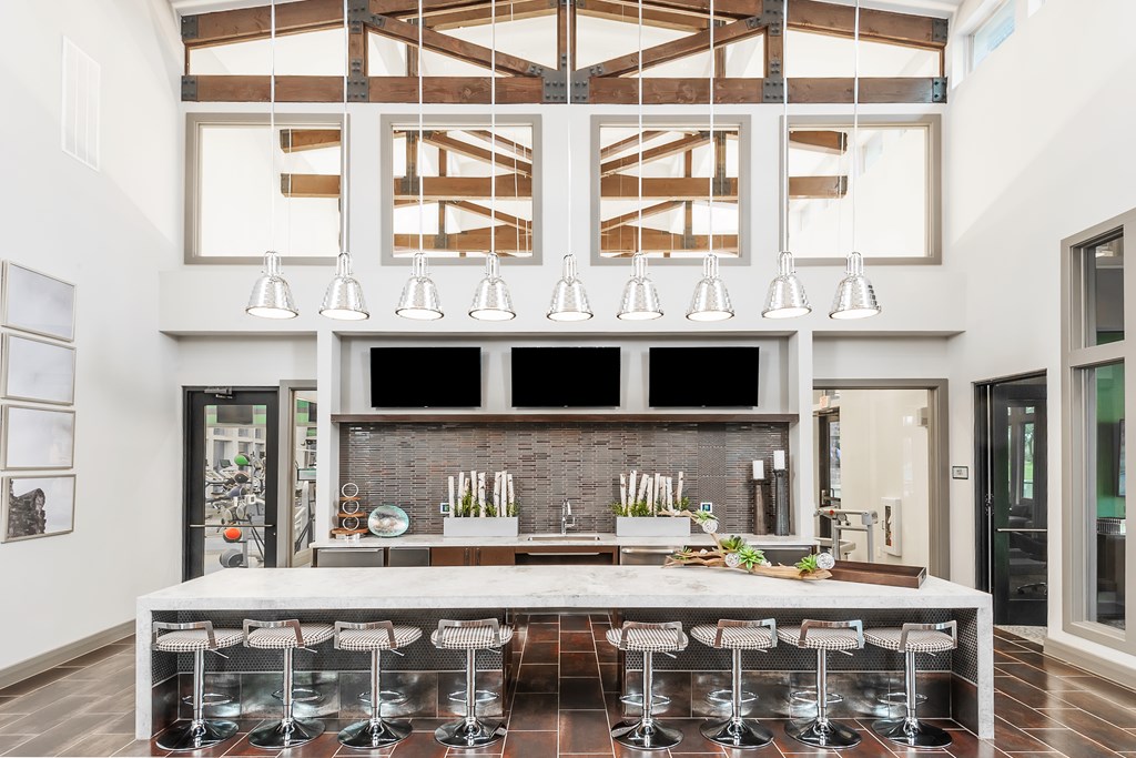 a large kitchen with a large island and chairs in front of a window