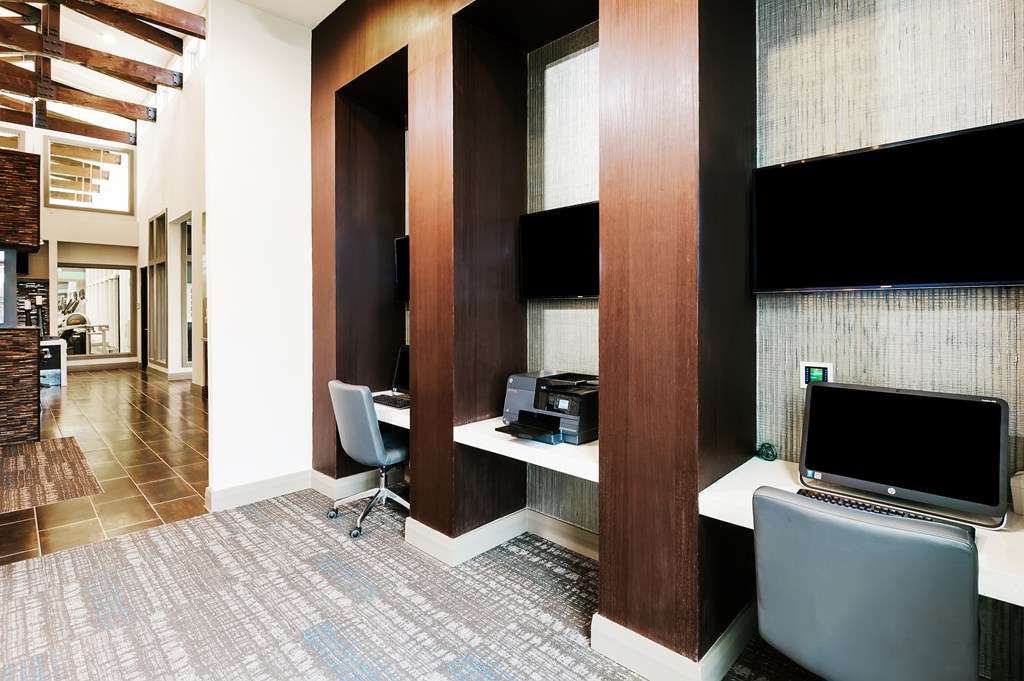 a business center with a television and a desk with a computer