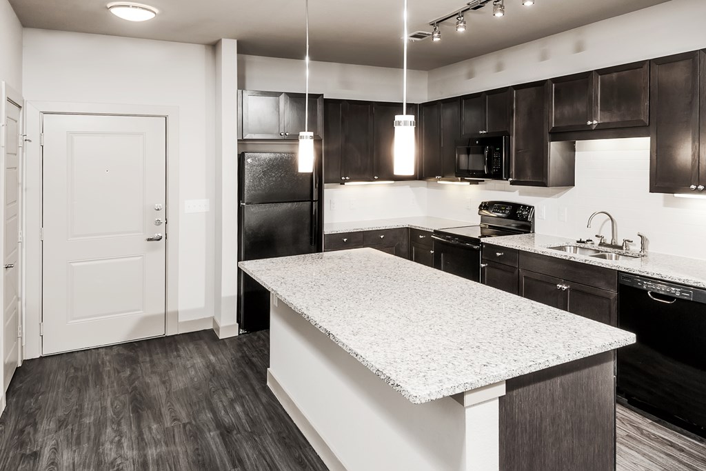 a kitchen with a marble counter top and black and white appliances