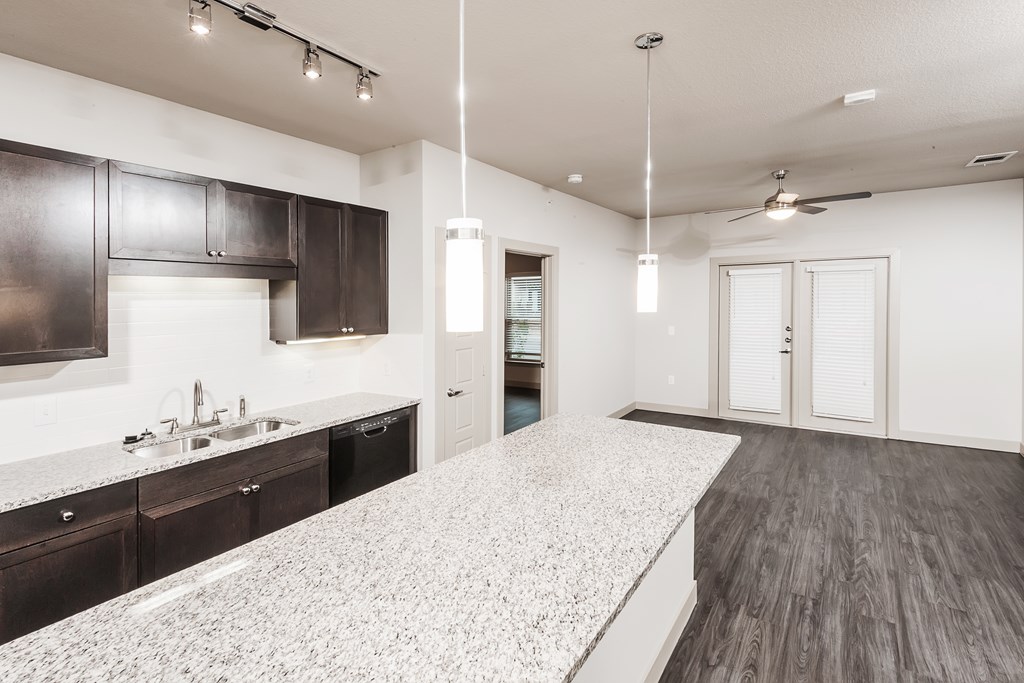 an empty kitchen with a large counter top and a sink