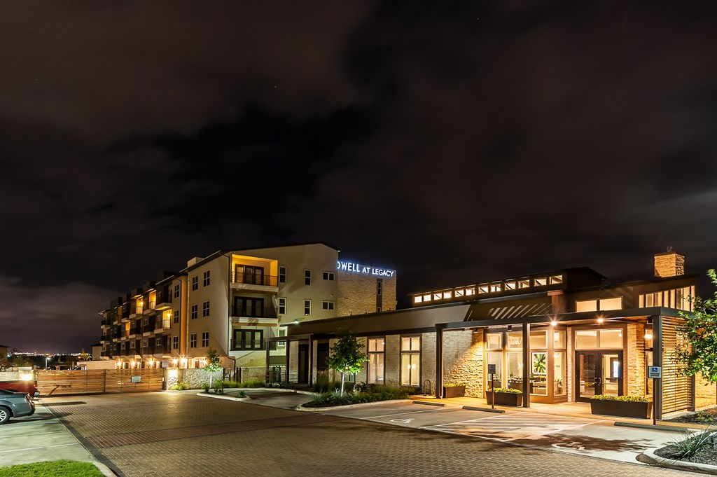 a hotel at night with its lights on and a dark sky