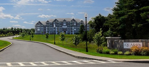 A road with a white line in the middle and a sign that says "Quarry" on the right.