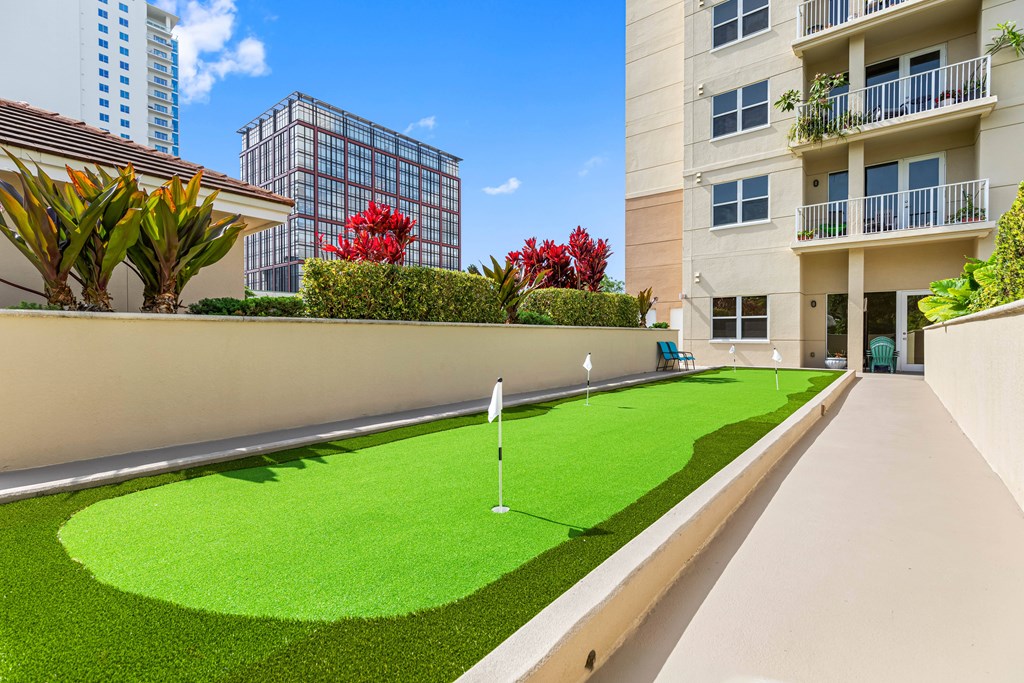 A miniature golf course is located on the balcony of an apartment building.