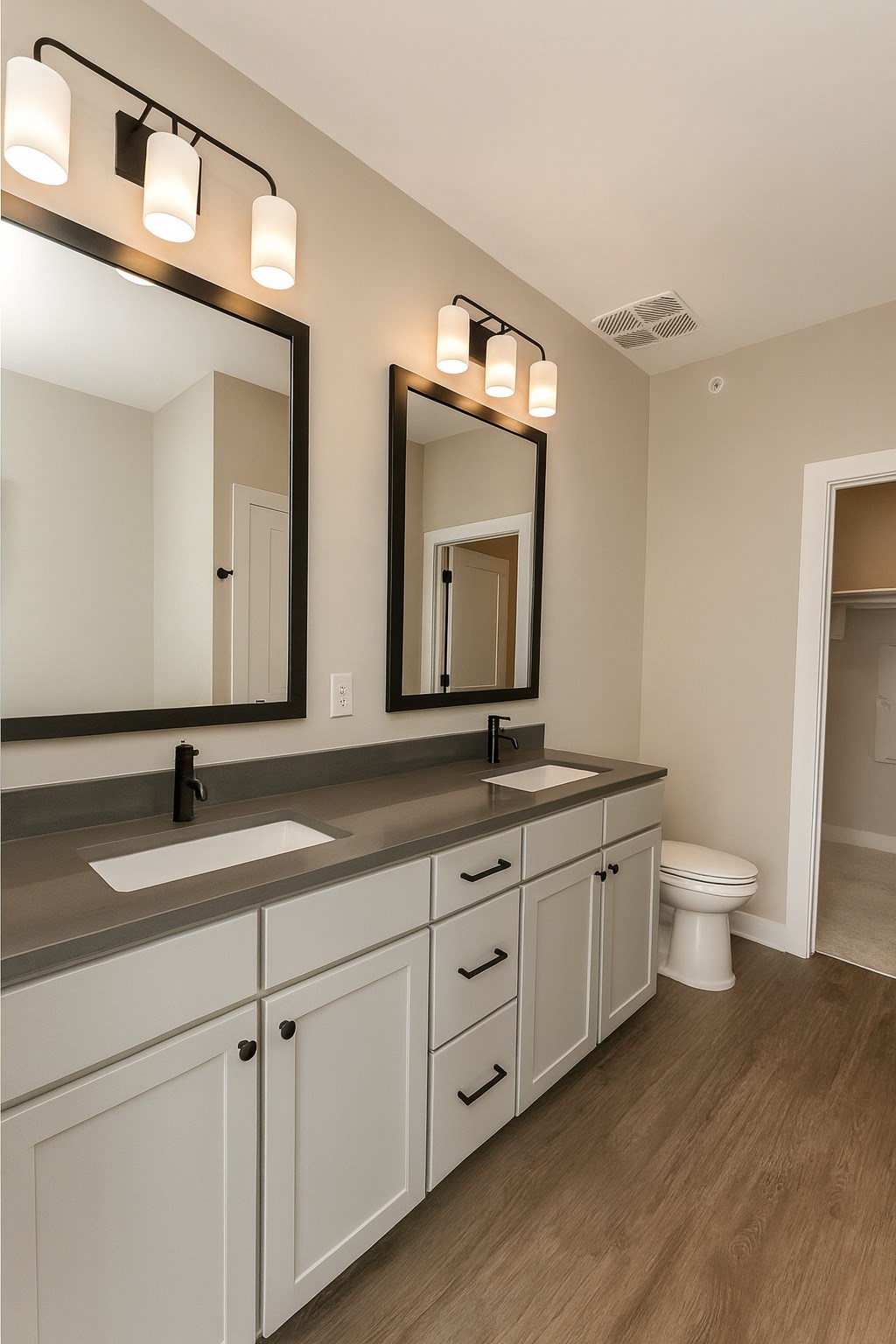 A bathroom with a sink, mirror, and lighting fixtures.