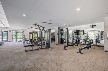 A gym with a variety of equipment including treadmills, weights, and exercise machines.