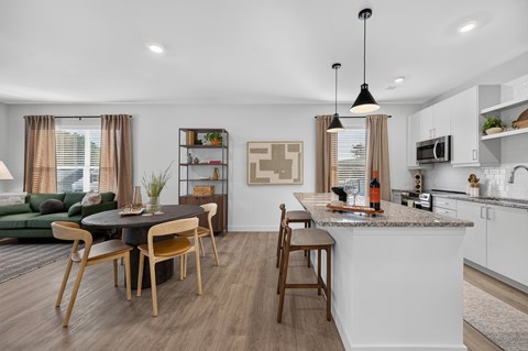 A modern kitchen with a dining table and chairs.