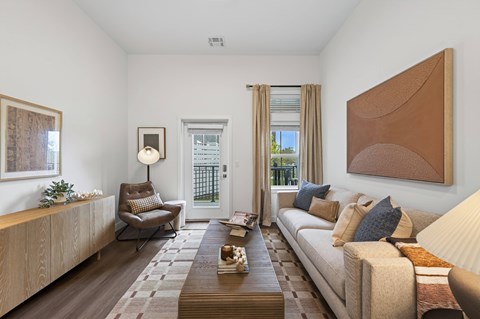 A living room with a brown couch, a coffee table, and a painting on the wall.