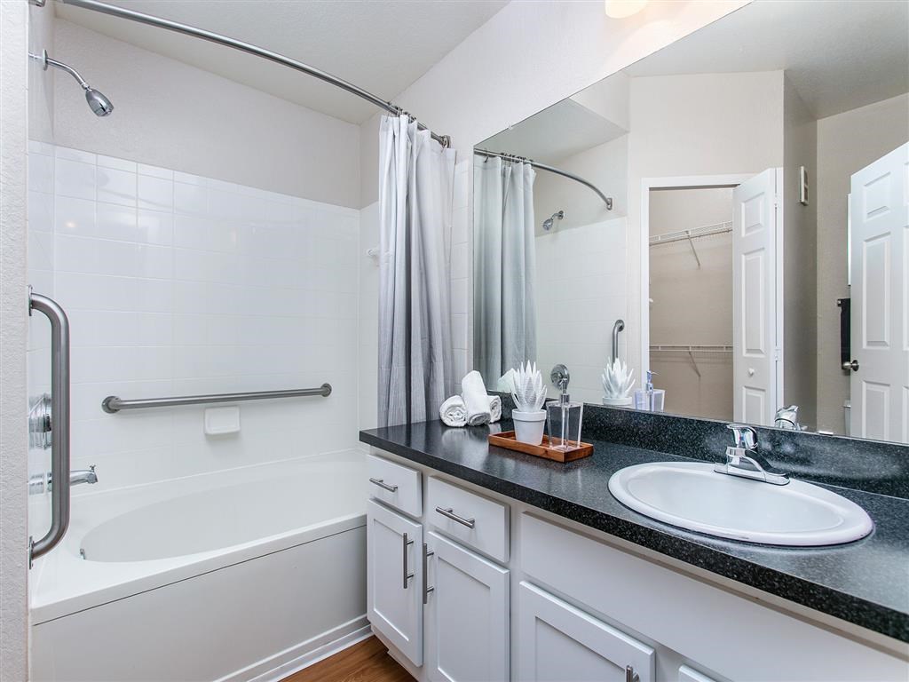 a bathroom with a sink and a tub and a mirror