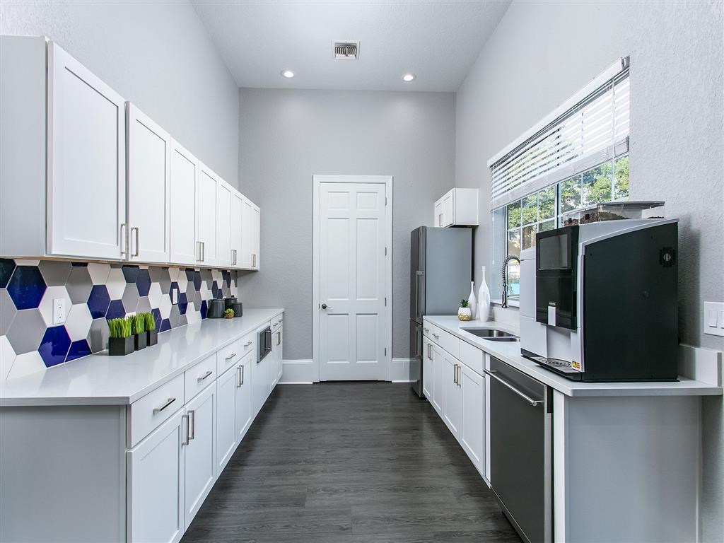a large kitchen with white cabinets and a black refrigerator
