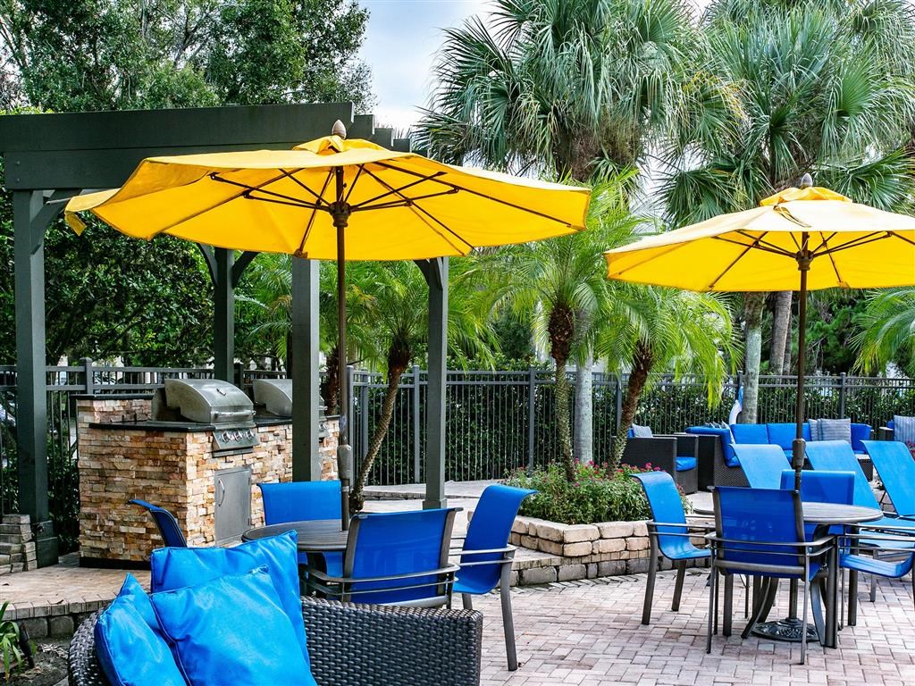 a patio with blue chairs and yellow umbrellas