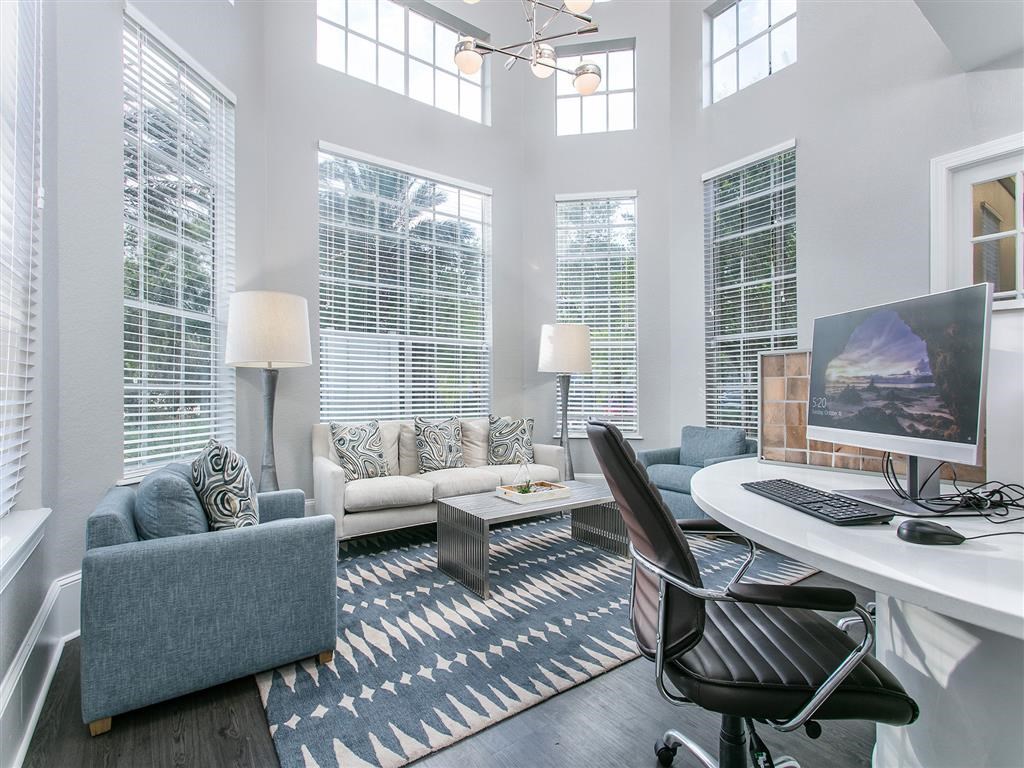 a living room with a desk with a computer on it