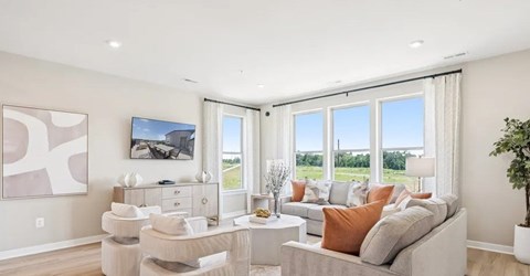 A living room with a couch, chairs, and a painting on the wall.