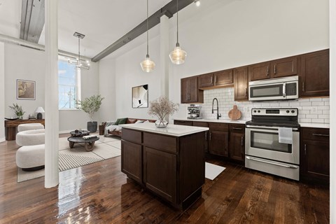 A modern kitchen with dark wood cabinets and stainless steel appliances.