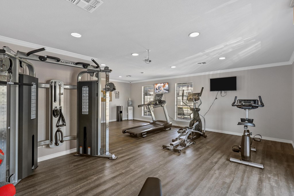 a home gym with exercise equipment and a tv