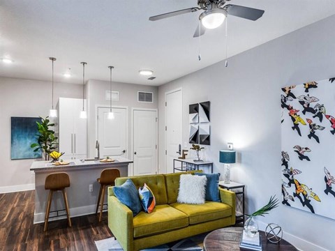 a living room with a couch in front of a kitchen